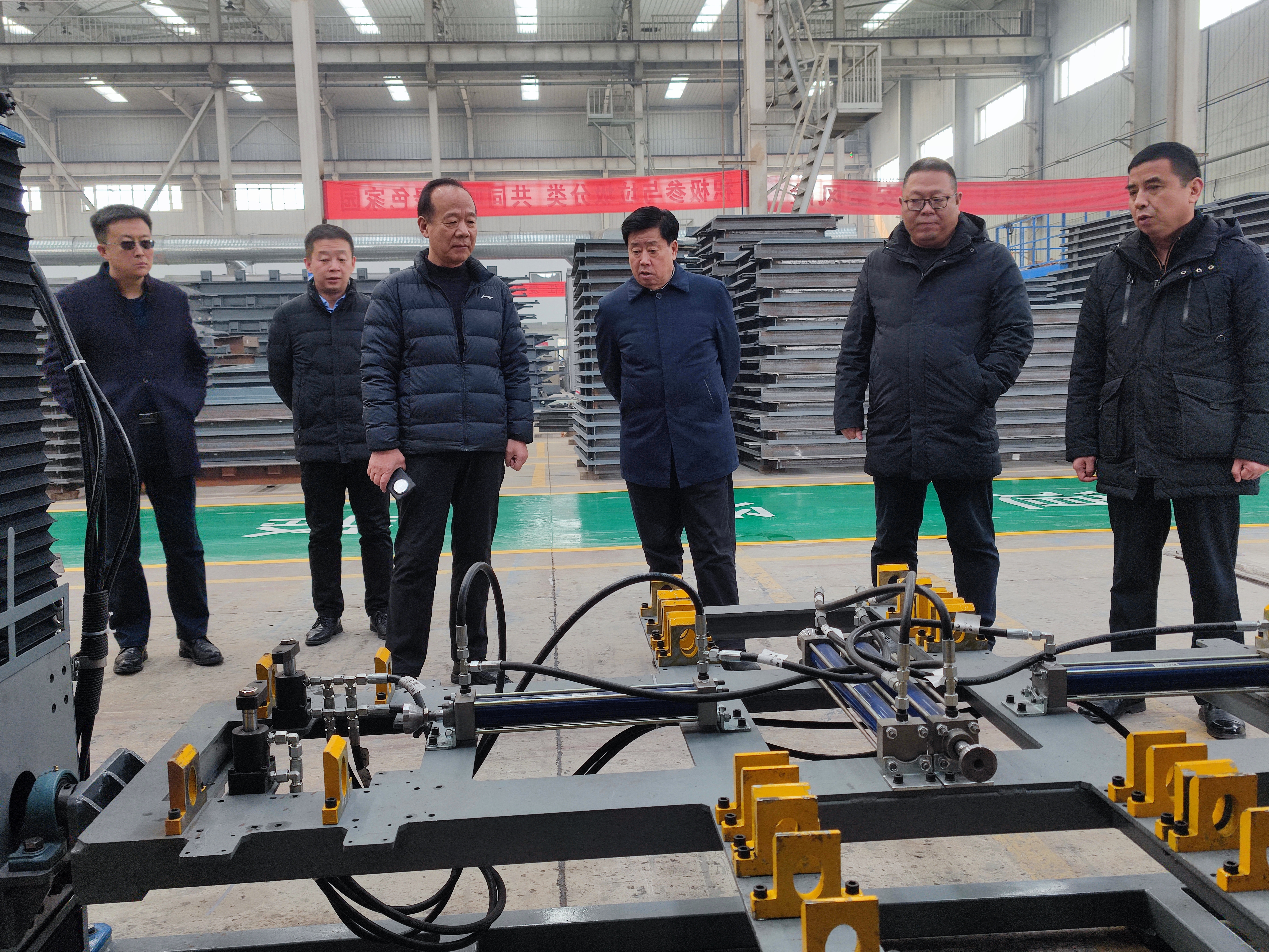 12月28日，谢辉在实业公司调研。在车间观看了自主研发设备“对框翻转一体机”的运转情况。（摄影：袁刚）.jpg